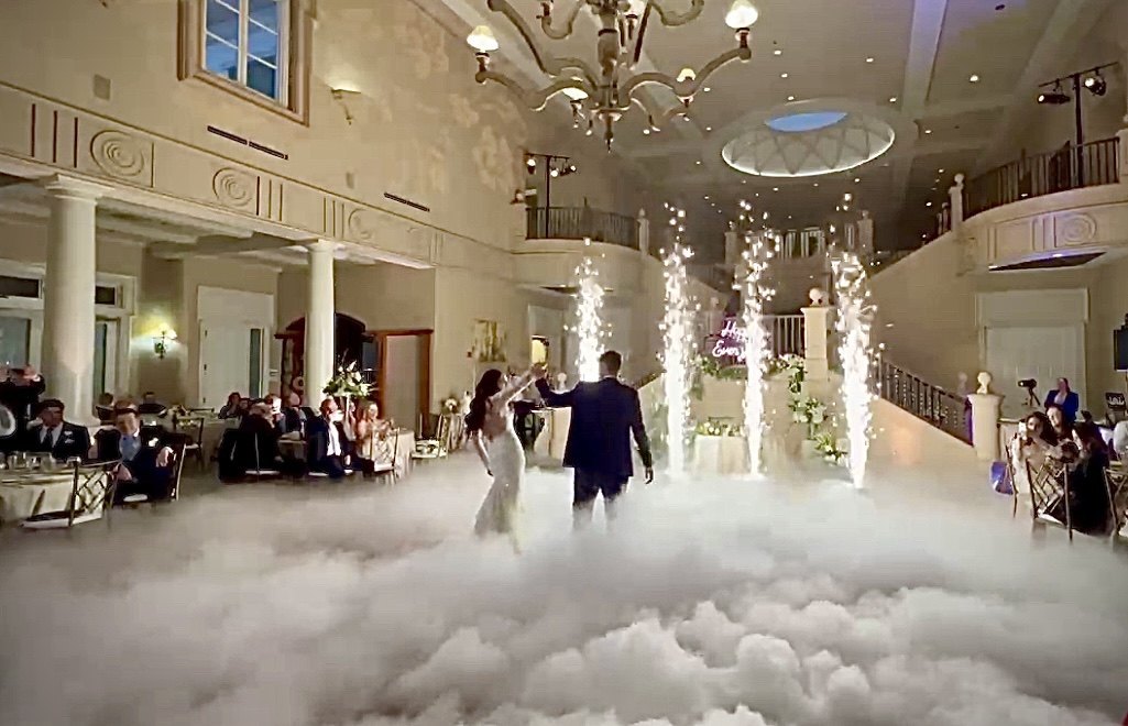 Couple dancing on the clouds with cold sparklers at their wedding
