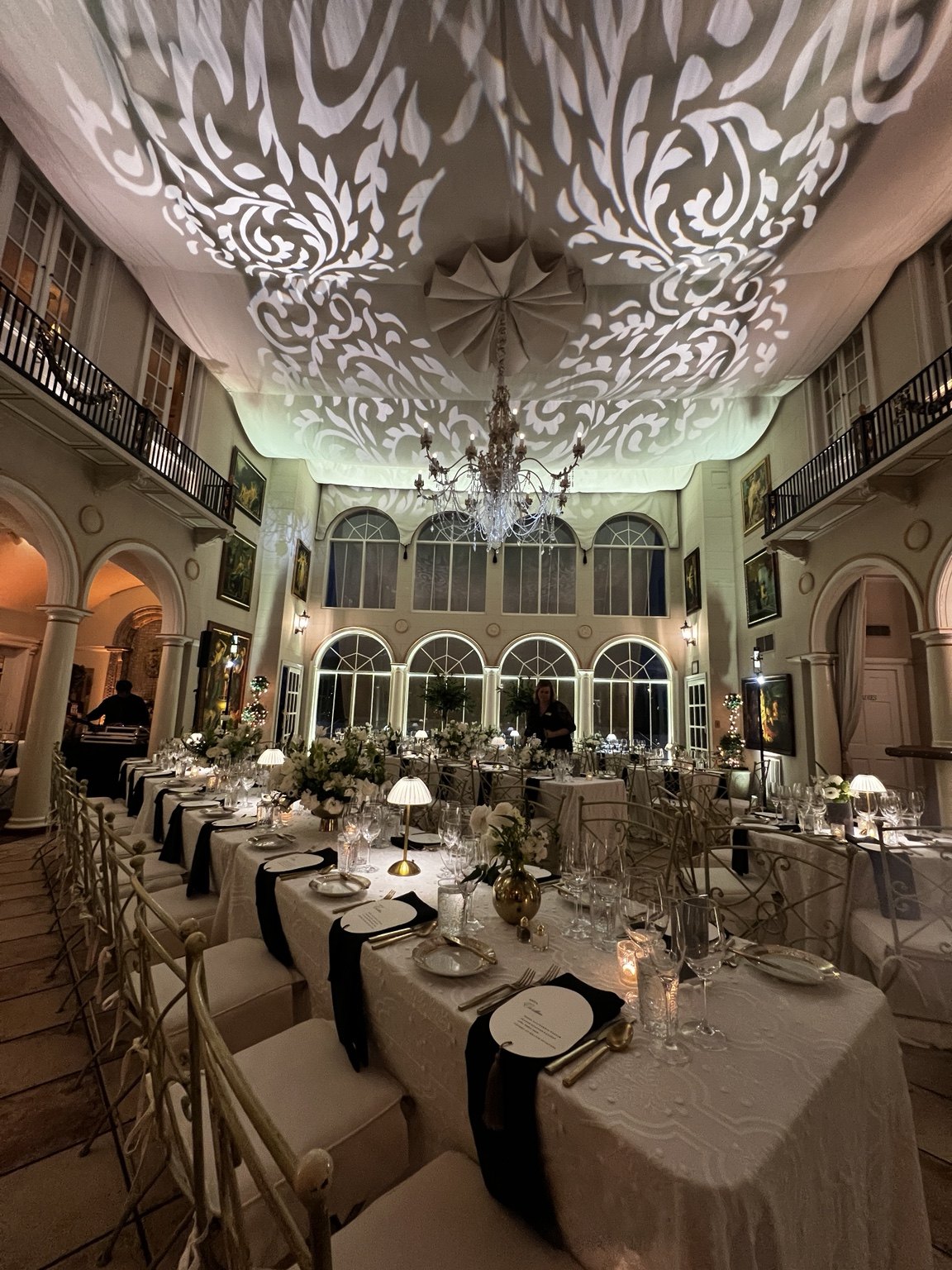 Pattern lighting projected across an elegant wedding reception ceiling